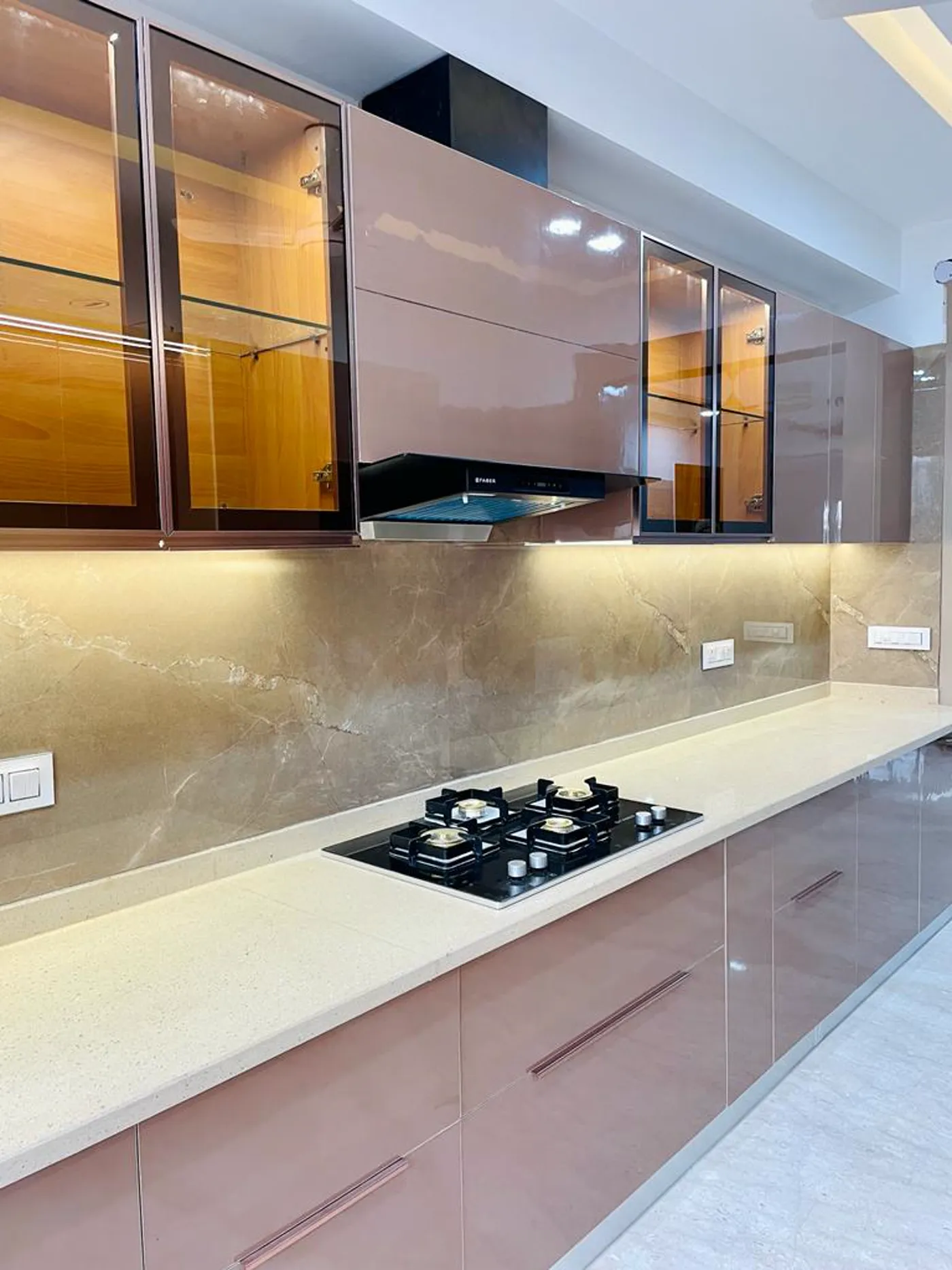 Modular kitchen with glossy mocha-brown cabinets and glass display units