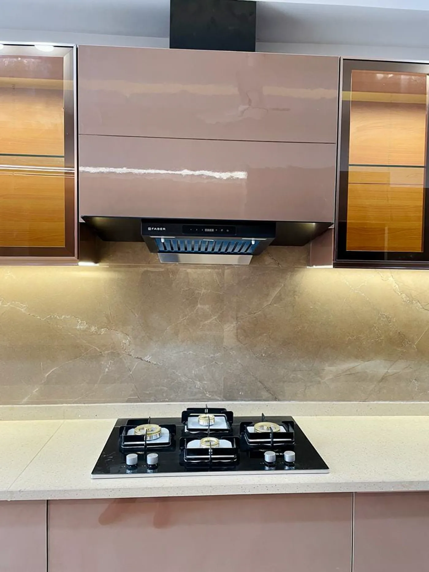 Close-up of kitchen gas hob and chimney with stone backsplash